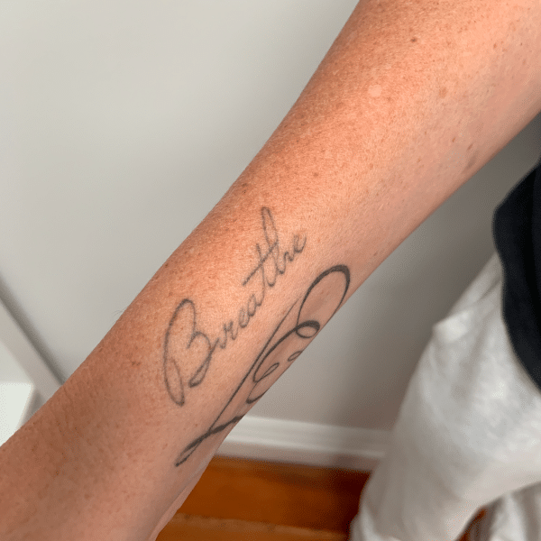 Forearm with "Breathe" tattoo, suitable for laser tattoo removal